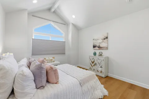 a bedroom with a bed and wooden floor