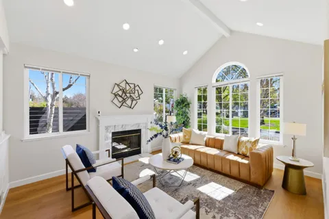 a living room with furniture fireplace and a large window