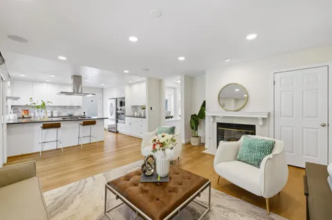 a living room with fireplace furniture and a view of kitchen