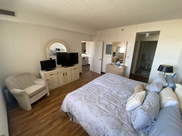 a bedroom with a bed window and mirror