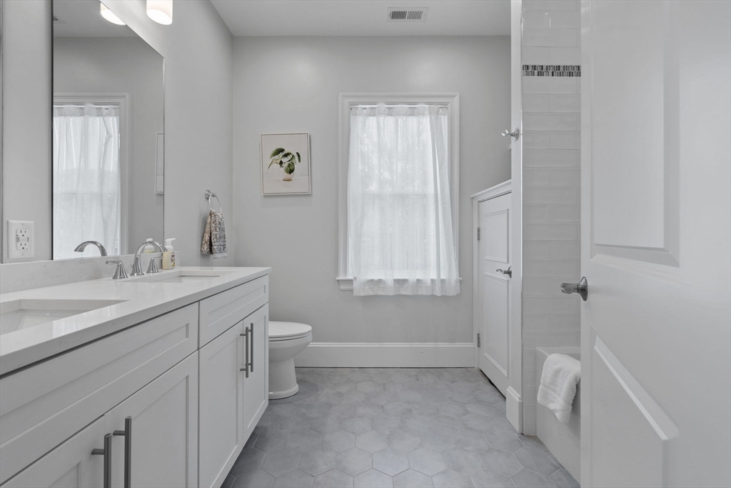 4 Coyne Road, Unit 4 Newton, MA 02468 - Photo 13 of 18 a bathroom with a double vanity sink a toilet and a shower