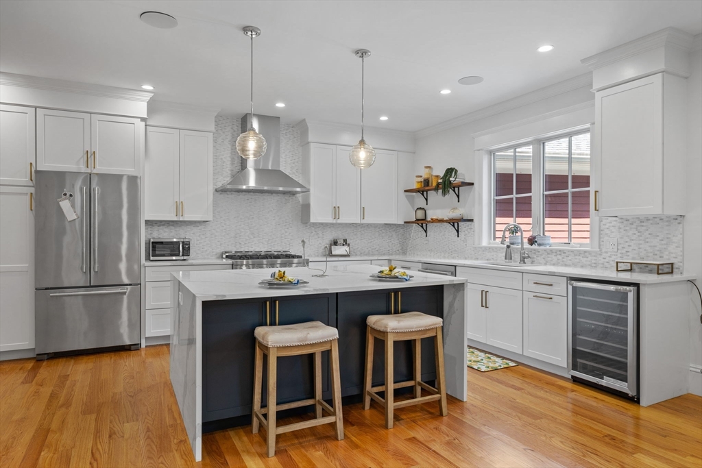 4 Coyne Road, Unit 4 Newton, MA 02468 - Photo 7 of 18 a kitchen with kitchen island granite countertop a sink a center island and stainless steel appliances