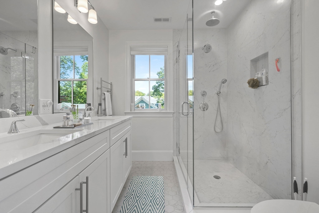 4 Coyne Road, Unit 4 Newton, MA 02468 - Photo 8 of 18 a bathroom with a granite countertop sink a large mirror a shower and a bathtub
