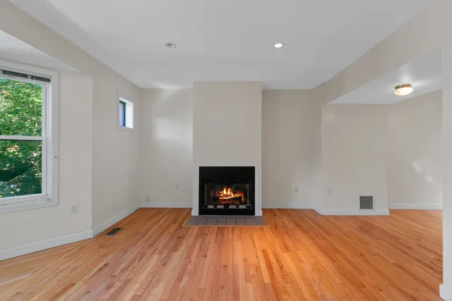 a view of a room with wooden floor and a fireplace