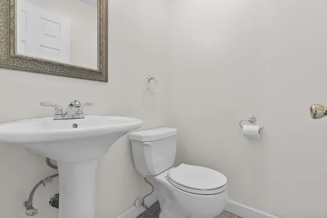 a bathroom with a sink a toilet and mirror
