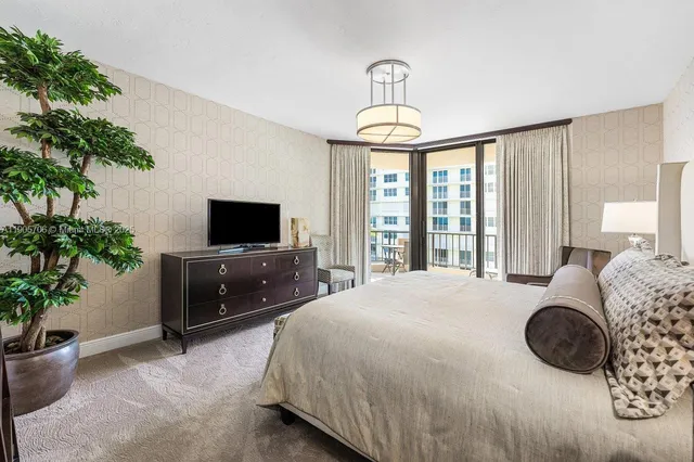 a living room with furniture a flat screen tv and a floor to ceiling window