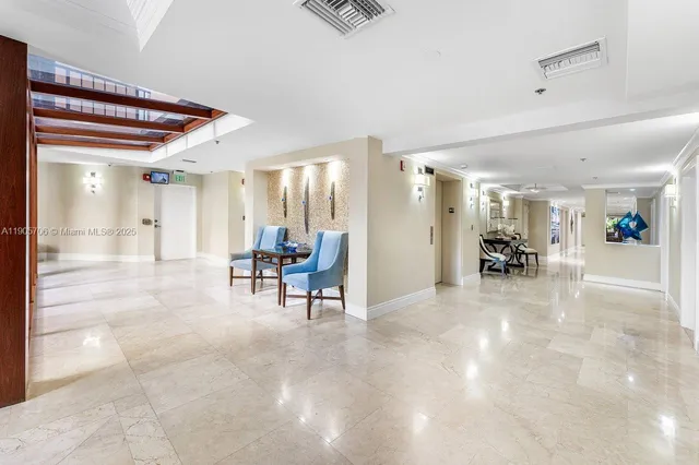 a view of a white building with a swimming pool and lawn chairs