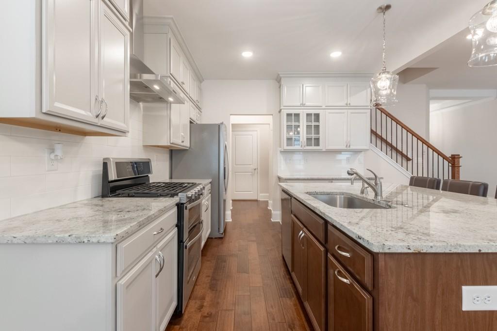 601 Cork Street Woodstock, GA 30188 - Photo 13 of 52 a kitchen with stainless steel appliances granite countertop a sink stove and refrigerator