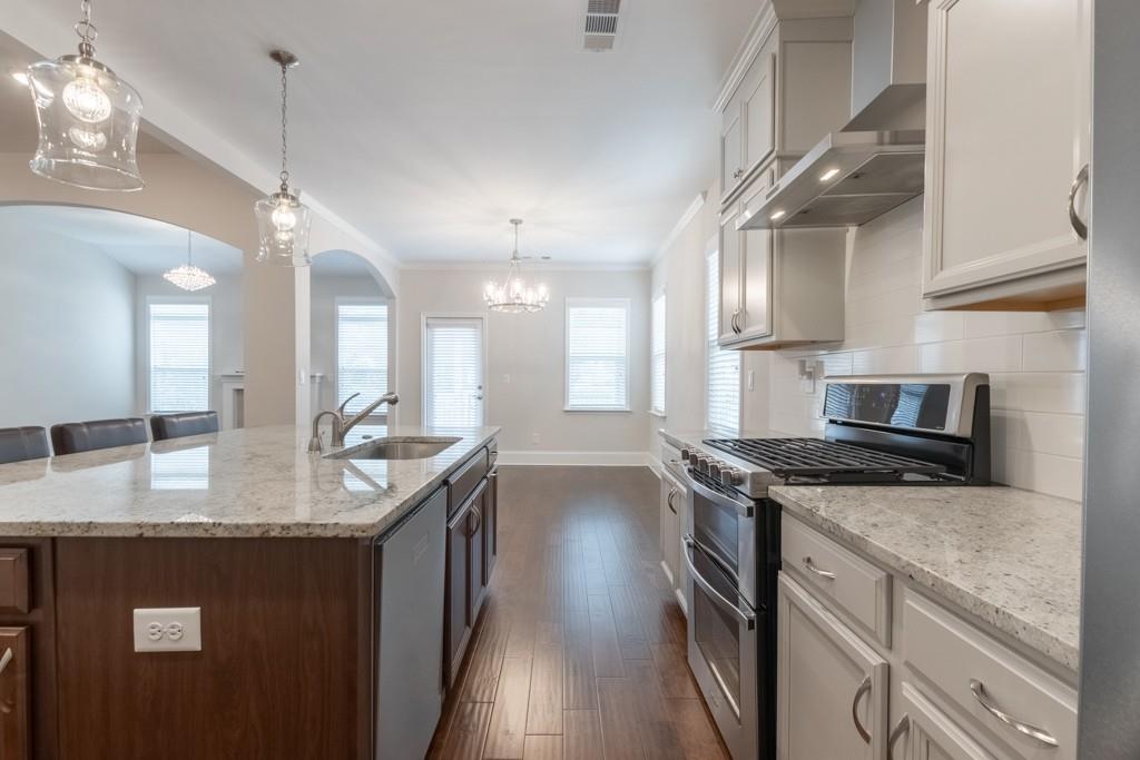 601 Cork Street Woodstock, GA 30188 - Photo 18 of 52 a kitchen with stainless steel appliances granite countertop a sink a stove and a wooden floors