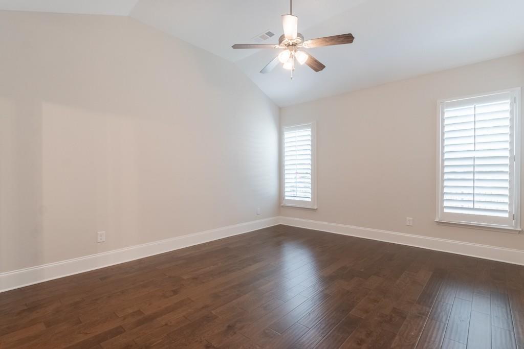 601 Cork Street Woodstock, GA 30188 - Photo 22 of 52 an empty room with wooden floor chandelier fan and windows