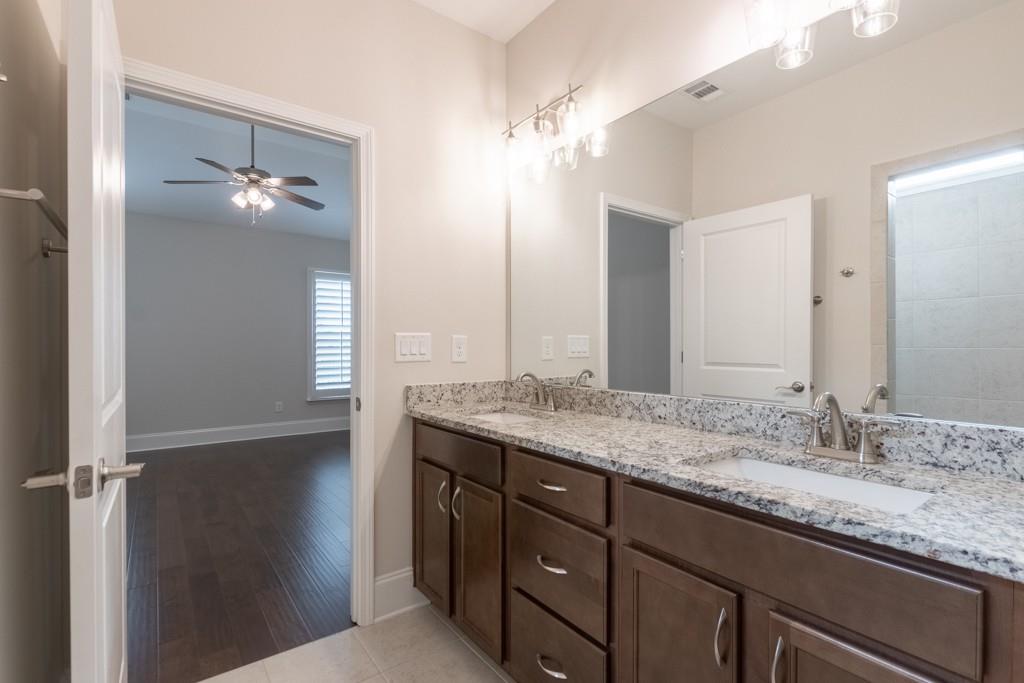 601 Cork Street Woodstock, GA 30188 - Photo 29 of 52 a bathroom with a granite countertop sink a light fixture and a mirror