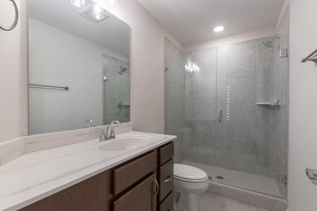 601 Cork Street Woodstock, GA 30188 - Photo 38 of 52 a bathroom with a sink a toilet a mirror and shower