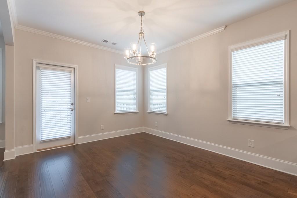 601 Cork Street Woodstock, GA 30188 - Photo 9 of 52 an empty room with wooden floor chandelier and windows