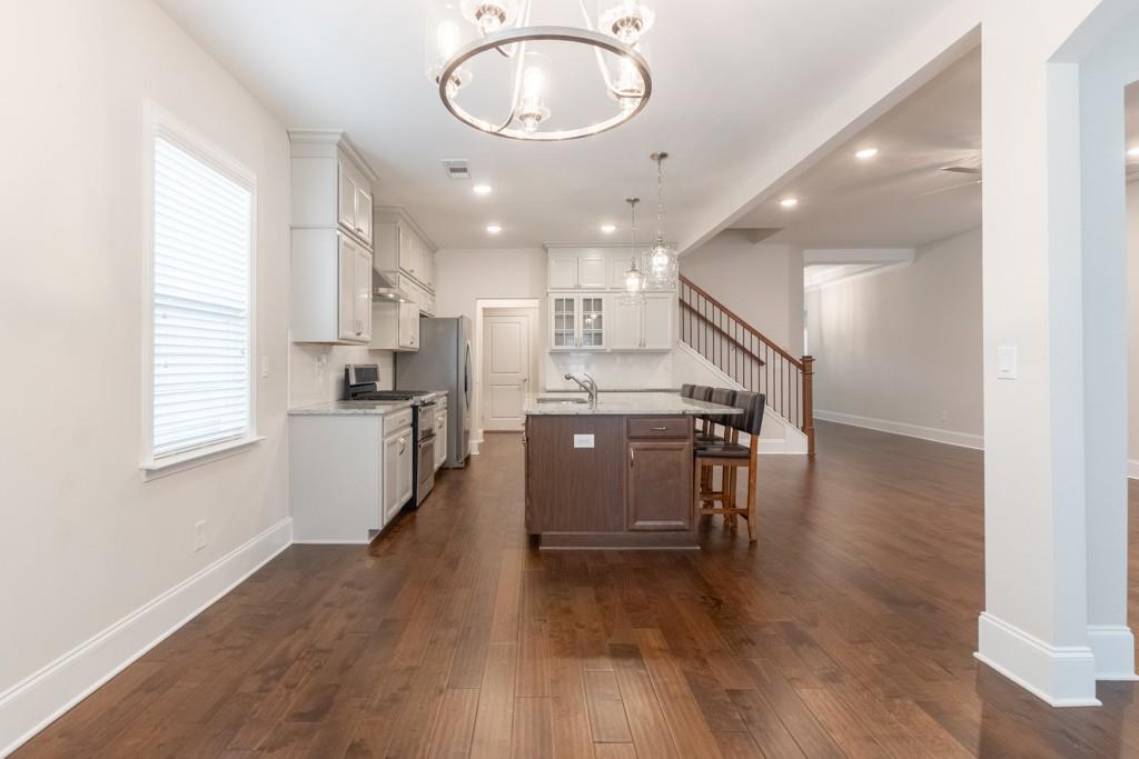 601 Cork Street Woodstock, GA 30188 - Photo 10 of 52 a kitchen with stainless steel appliances granite countertop a stove top oven a sink a counter space and cabinets