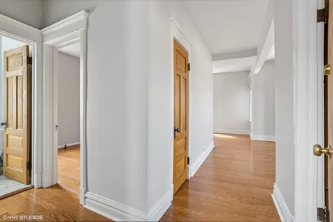 a view of a hallway with wooden floor and staircase