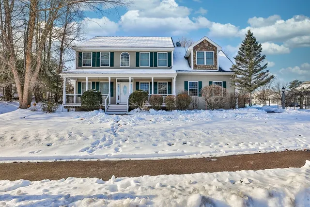a front view of a house with a yard covered with snow