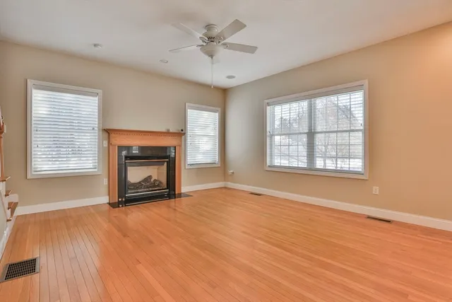 a view of an empty room with a fireplace and a window