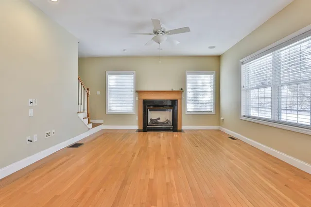 a view of an empty room with a fireplace and a window