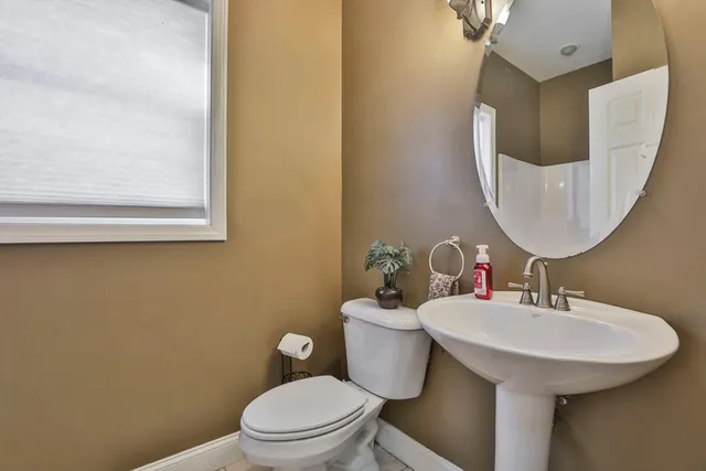 a bathroom with a toilet a sink and mirror