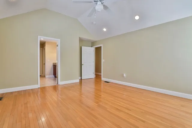 a view of an empty room with wooden floor