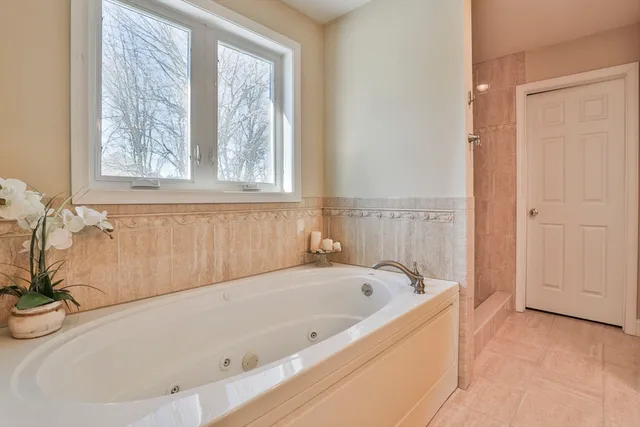 a white bath tub sitting in a bathroom next to a window