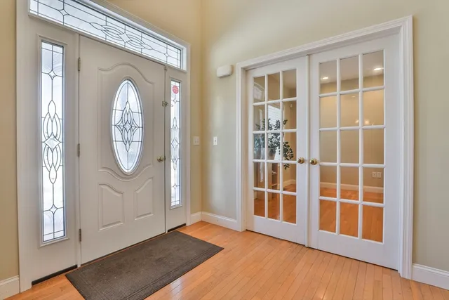 a view of front door with wooden floor and windows
