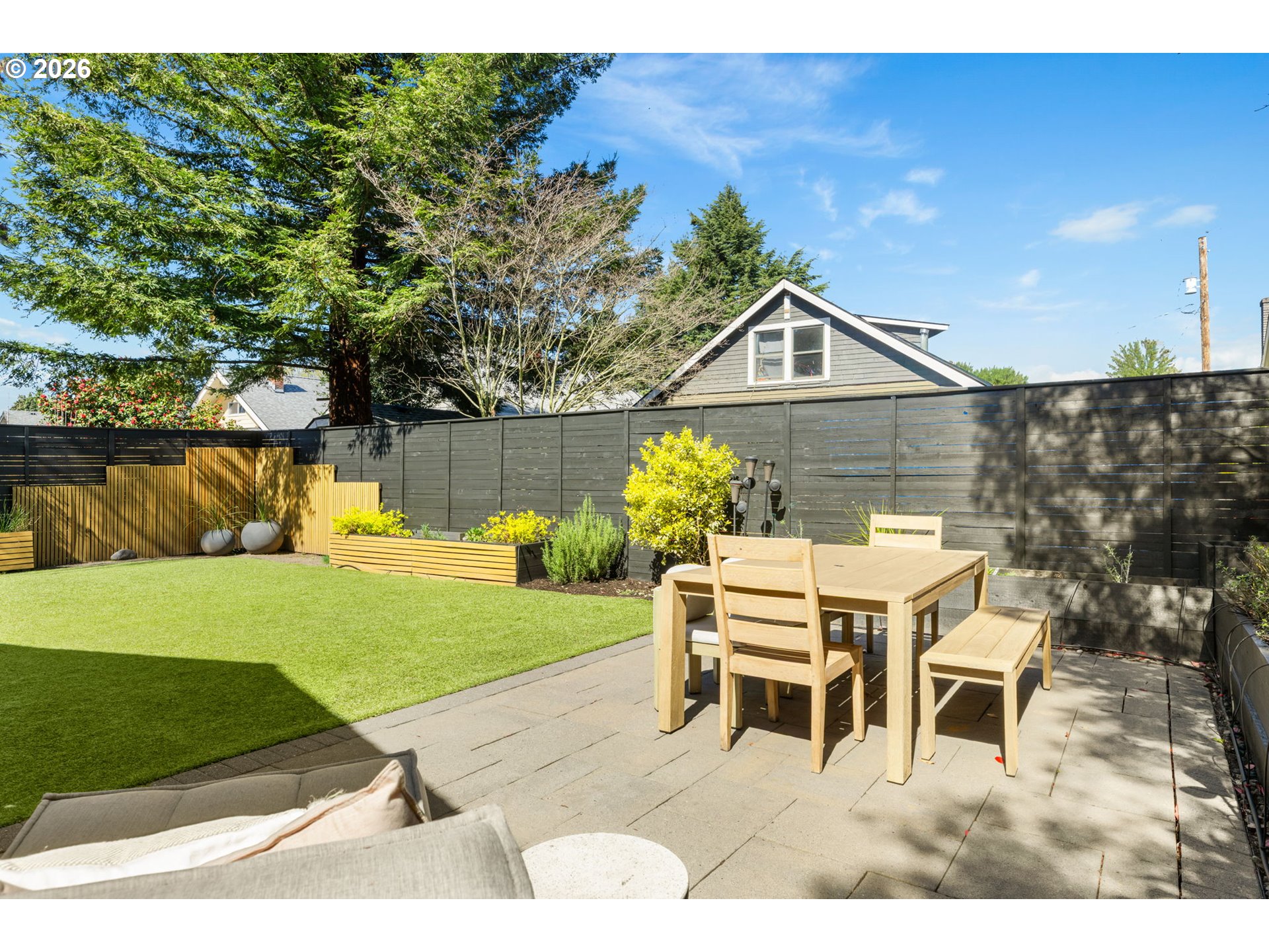 2025 North Alberta Street Portland, OR 97217 - Photo 47 of 48 a white house with a yard potted plants and a large tree