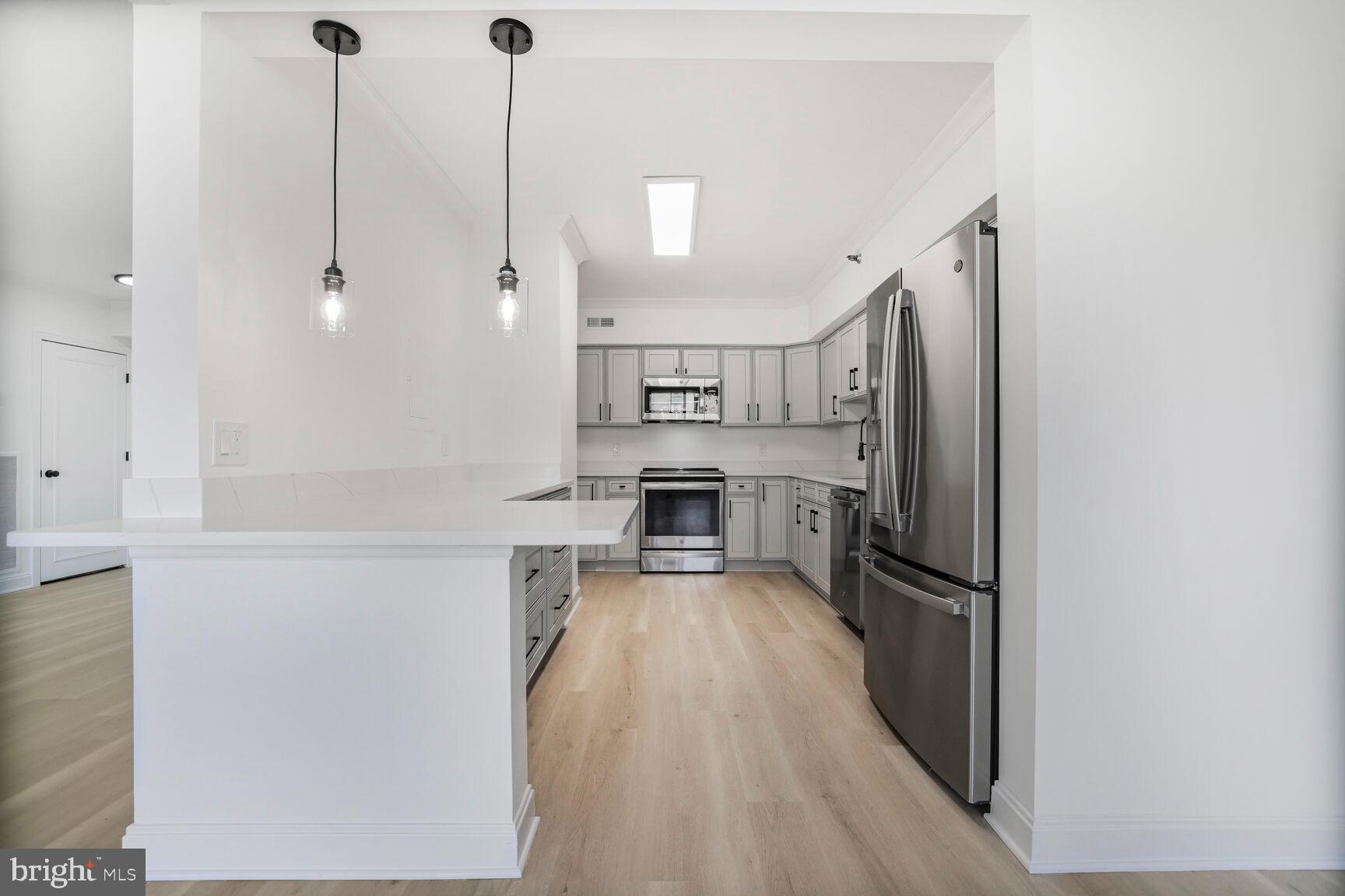 4550 North Park Avenue, Unit 707 Chevy Chase, MD 20815 - Photo 6 of 15 a kitchen with stainless steel appliances a refrigerator and a stove