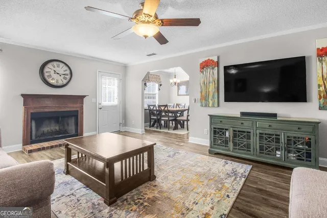 a living room with furniture a flat screen tv and a fireplace