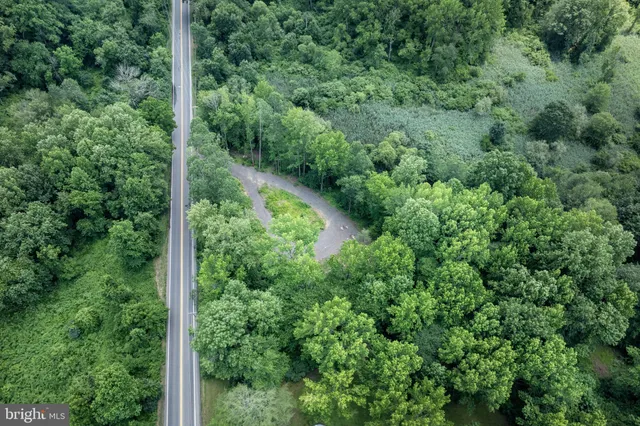 an aerial view of residential house with outdoor space and trees all around