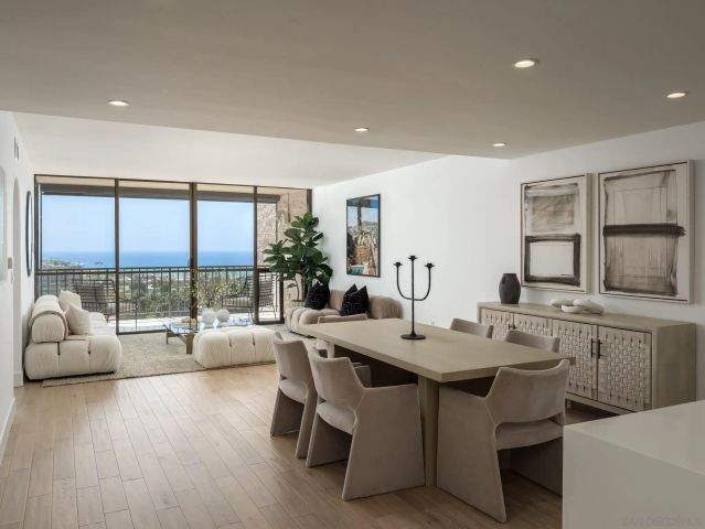 a large white kitchen with a large window and white table