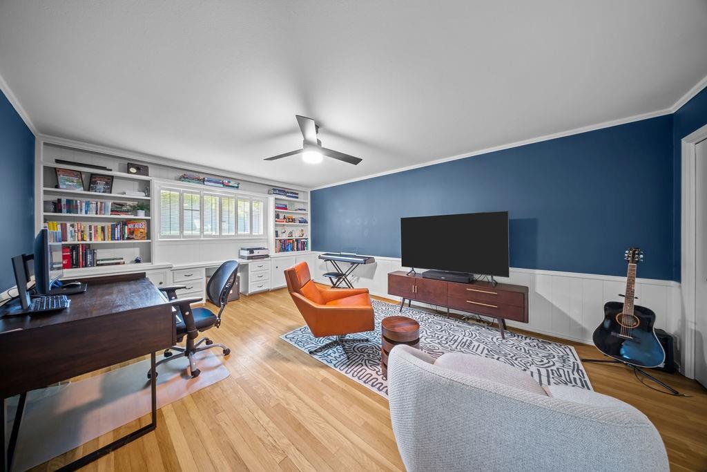11714 El Hara Circle Dallas, TX 75230 - Photo 29 of 40 a living room with furniture a bookshelf and a flat screen tv