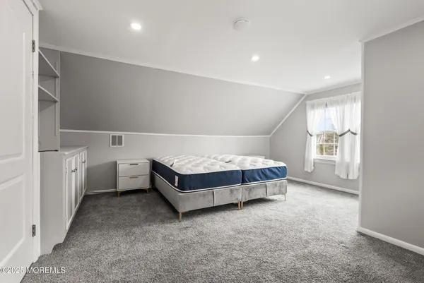 a spacious bedroom with a bed and a window