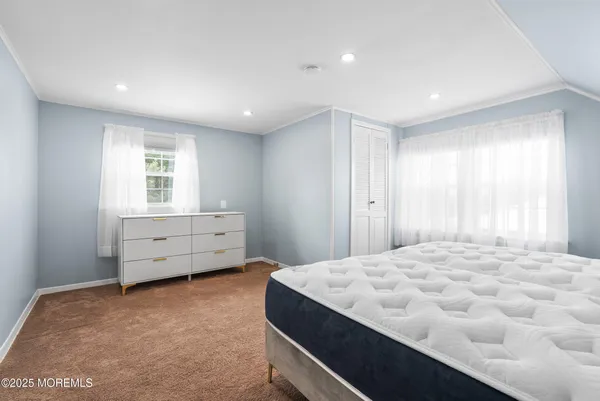 a large bedroom with a bed and a window