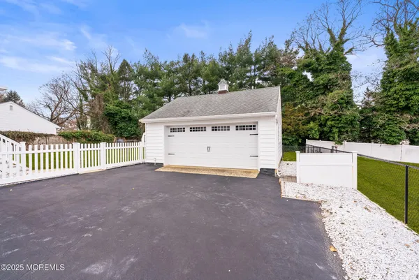 a view of a white house with a yard and large tree