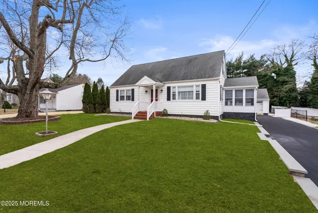 a front view of a house with a garden and yard