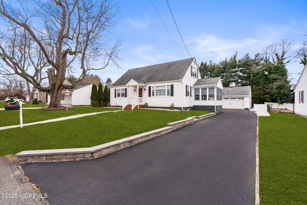 a view of a house with a big yard and large trees