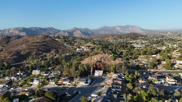 an aerial view of residential houses with outdoor space and trees