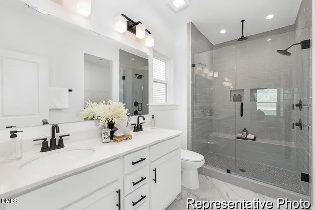 a bathroom with a shower sink vanity mirror and shower