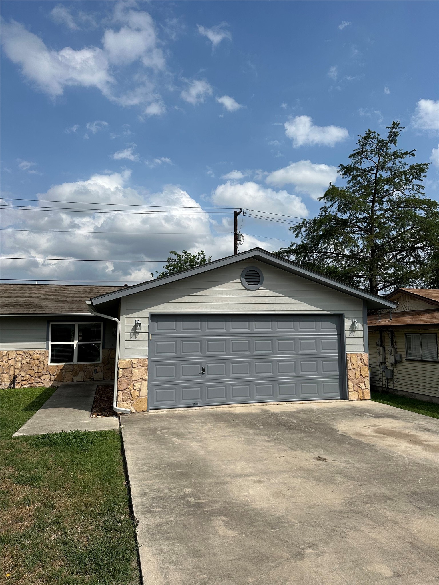 2743 Maple Tree Road, Unit A New Braunfels, TX 78130 - Photo 15 of 18 Ranch-style house with stone siding, concrete driveway, and a garage