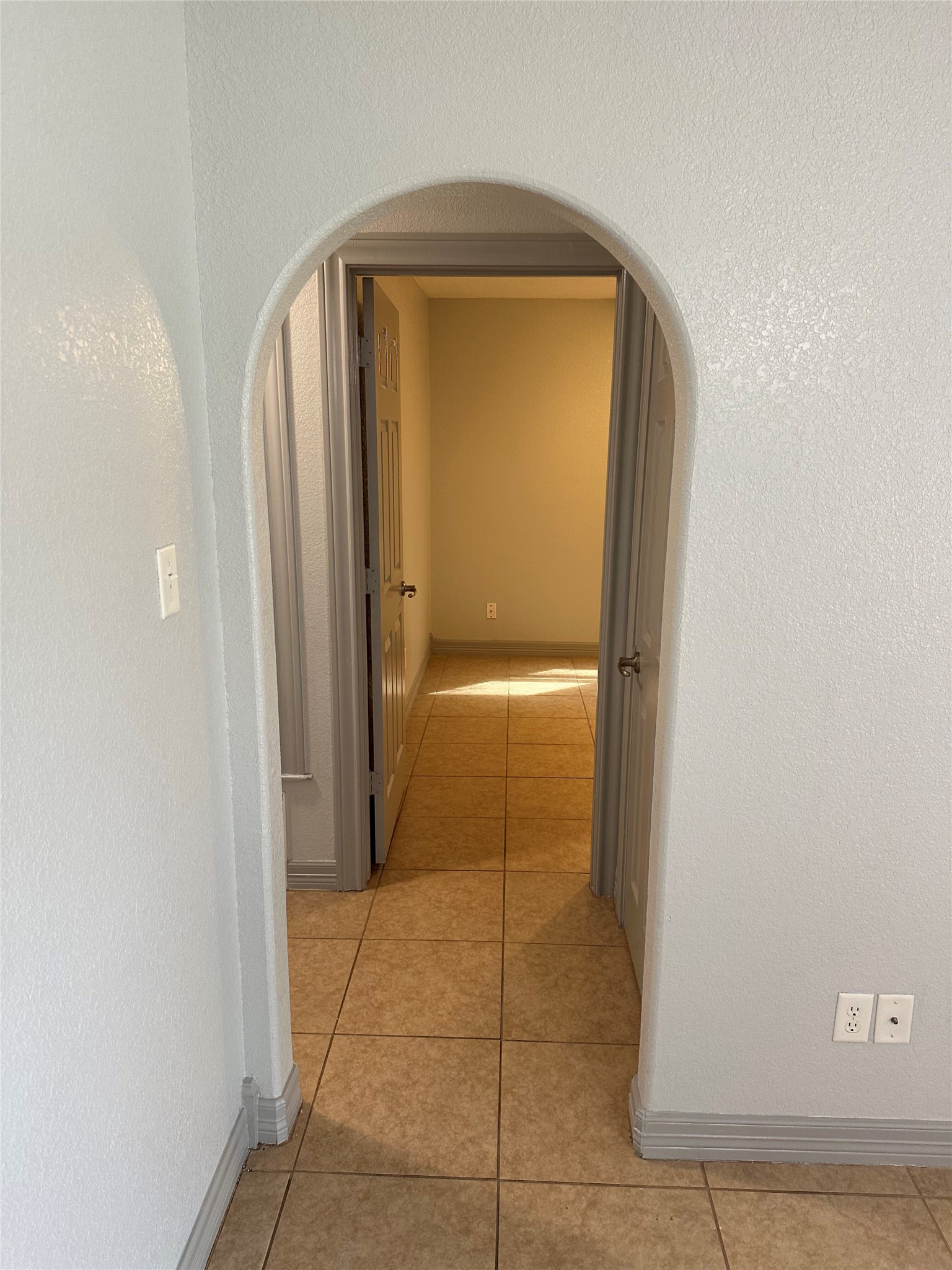 2743 Maple Tree Road, Unit A New Braunfels, TX 78130 - Photo 4 of 18 Hallway featuring a textured wall, arched walkways, and light tile patterned flooring