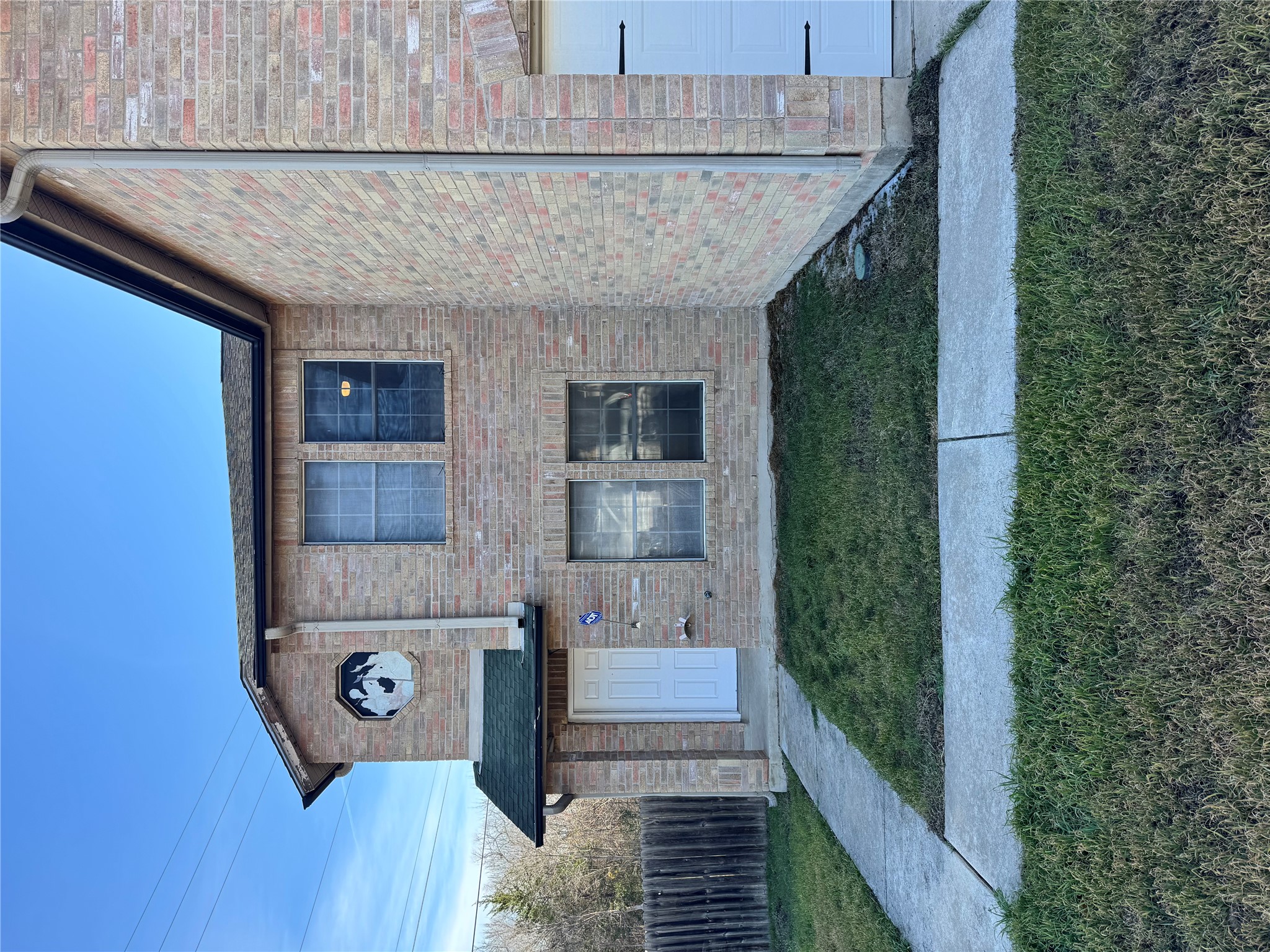 View of front of house featuring brick siding and a garage