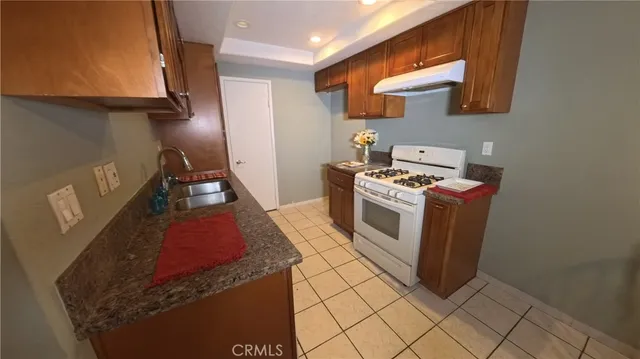 a kitchen with stainless steel appliances granite countertop a stove a sink and a microwave