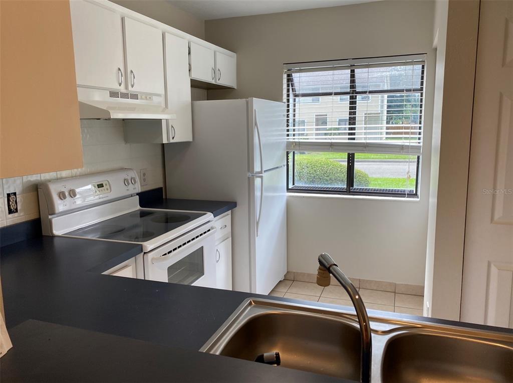 6138 Southwest 8th Lane Gainesville, FL 32607 - Photo 3 of 9 a kitchen with a refrigerator and a sink