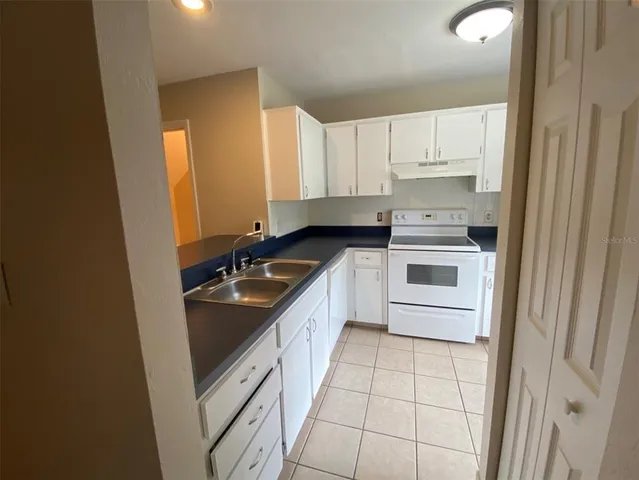 a kitchen with a sink a stove and cabinets