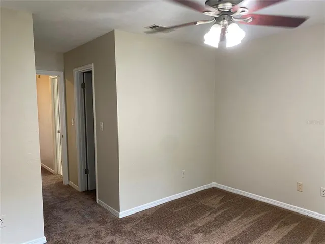 an empty room with a chandelier fan and a chandelier fan