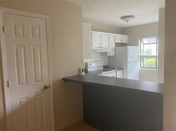 a kitchen with a sink a window and cabinets