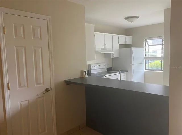 a kitchen with a sink a window and cabinets