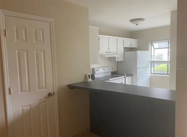 a kitchen with a sink a window and cabinets