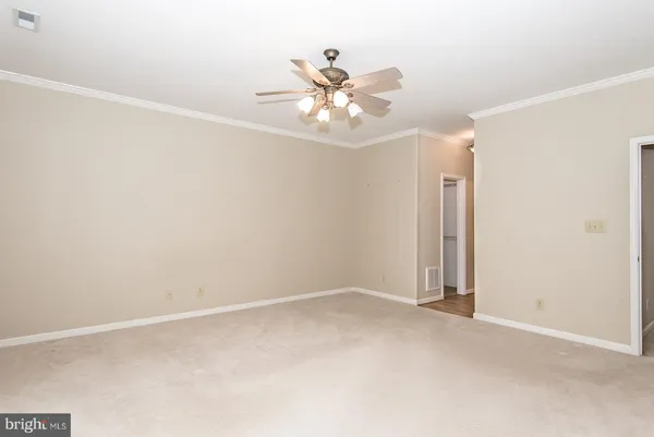an empty room with a window and a ceiling fan